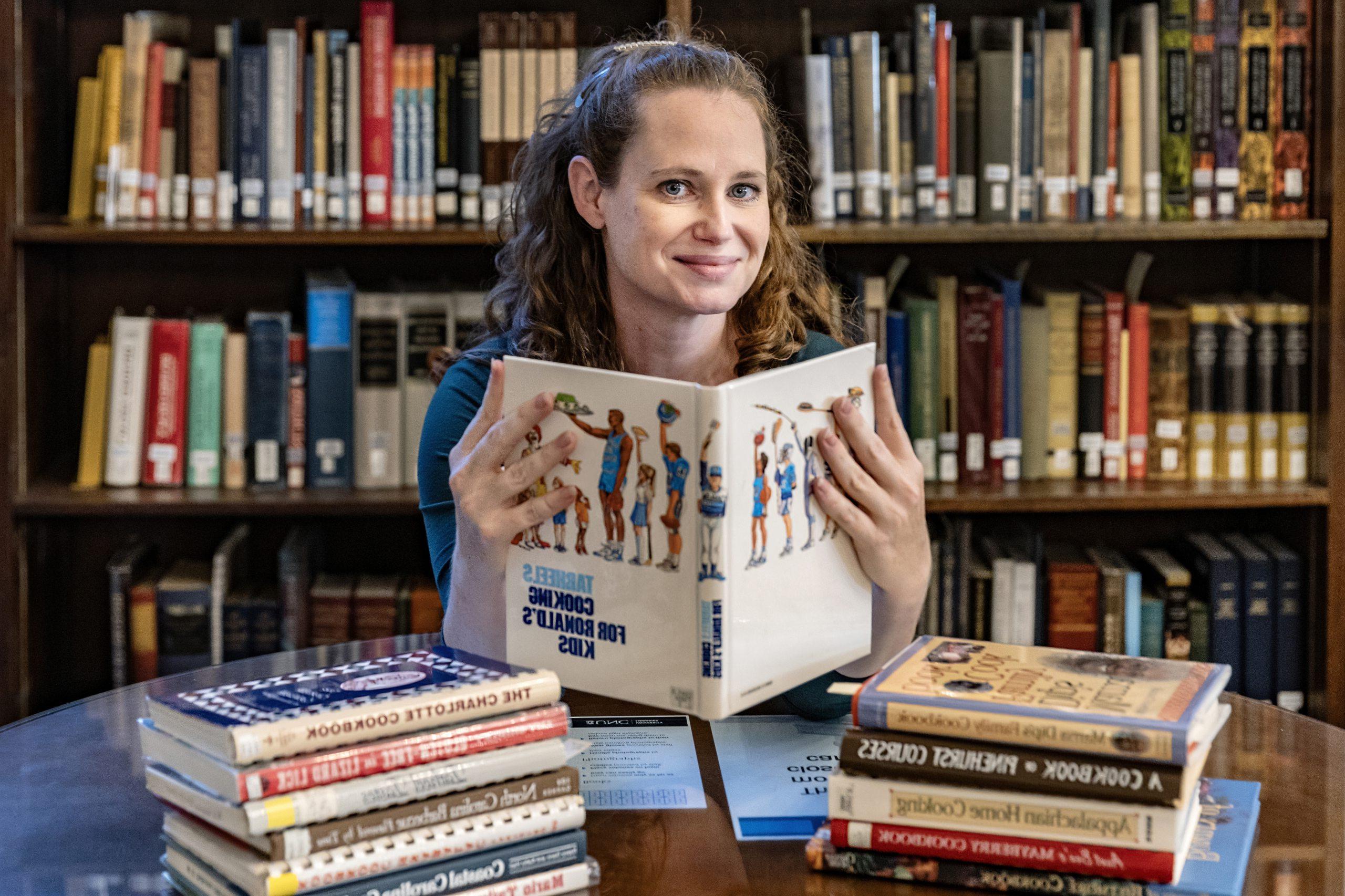 Alison Barnett holding a cookbook.